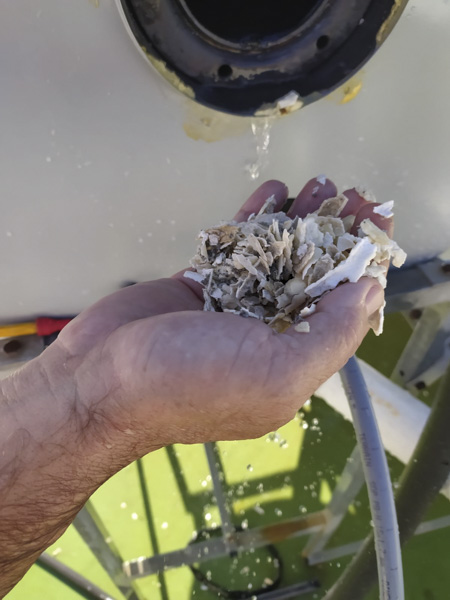 Mano sosteniendo deshechos de tubería