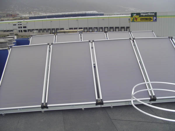 Paneles de energía solar térmica en azotea al lado de Hiperdino